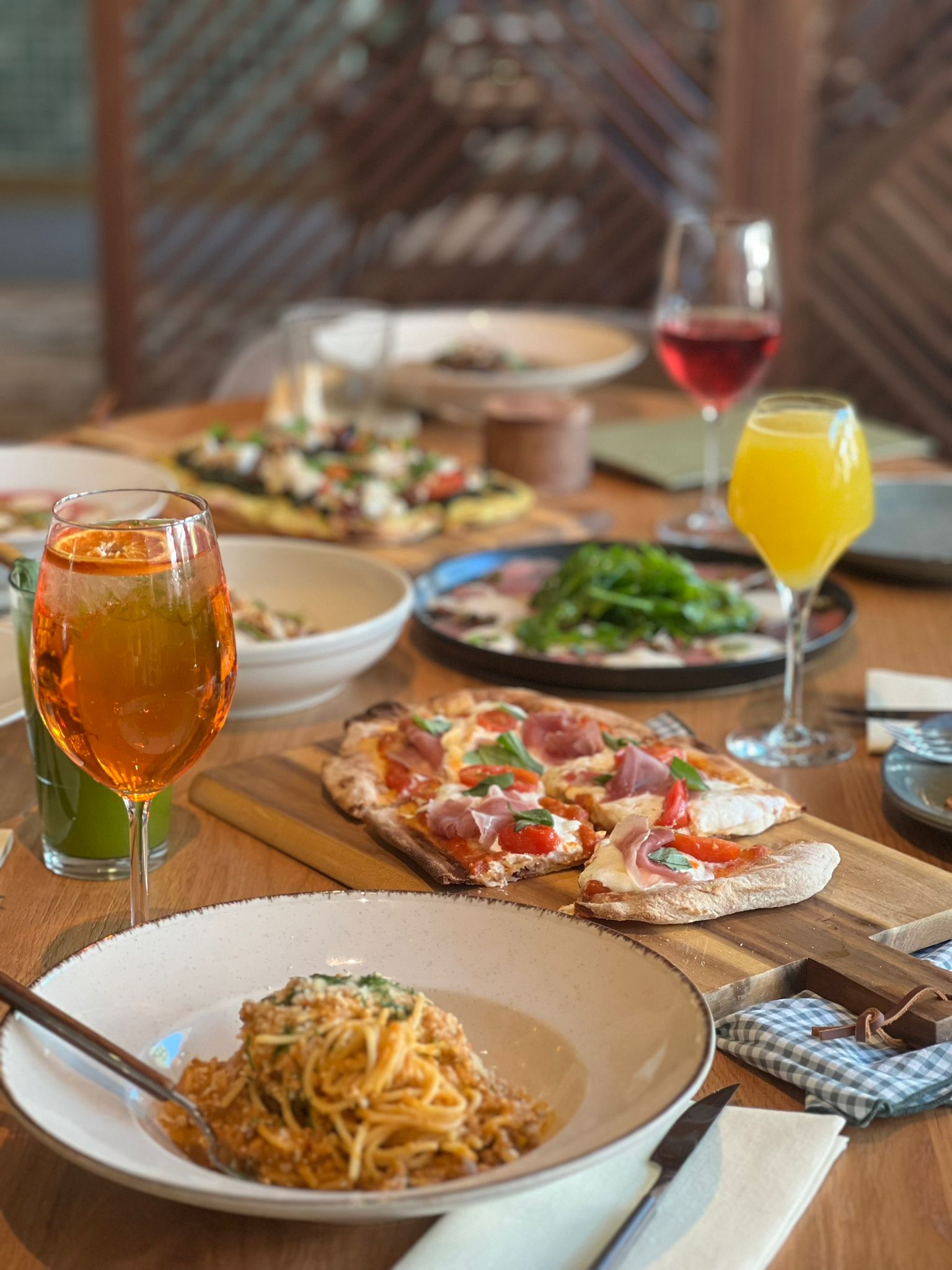 Table with pizza, pasta and cocktails at Casica Trattoria